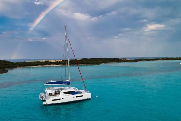 yacht on water with rainbow