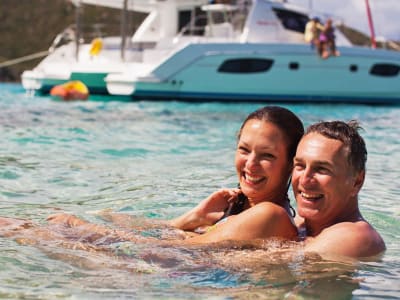 couple-swimming-infront-of-yacht