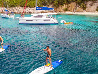 Catamaran Anchoring and People Stand Up Paddling Corfu Island